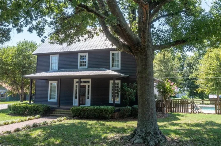 Two-story residence featuring dark siding and white trim