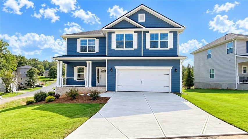 Two-story residence featuring blue siding, white trim, and a covered front porch with white columns