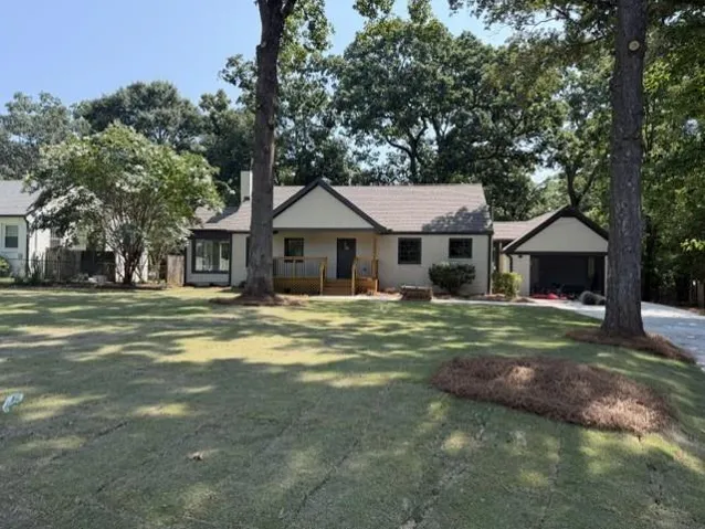 Charming single-story residence featuring a cream-colored exterior with dark trim accents and a pitched roofline