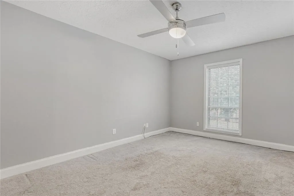 Unfurnished bedroom with light carpet, a closet, and ceiling fan