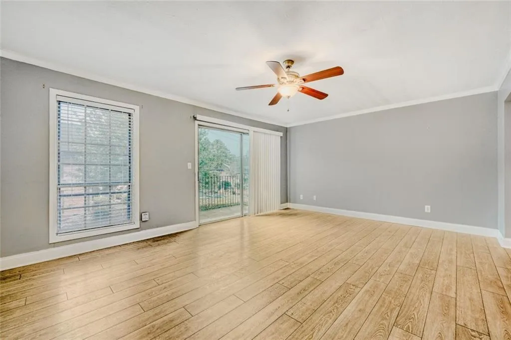 Unfurnished room featuring crown molding, a ceiling fan, and light wood finished floors