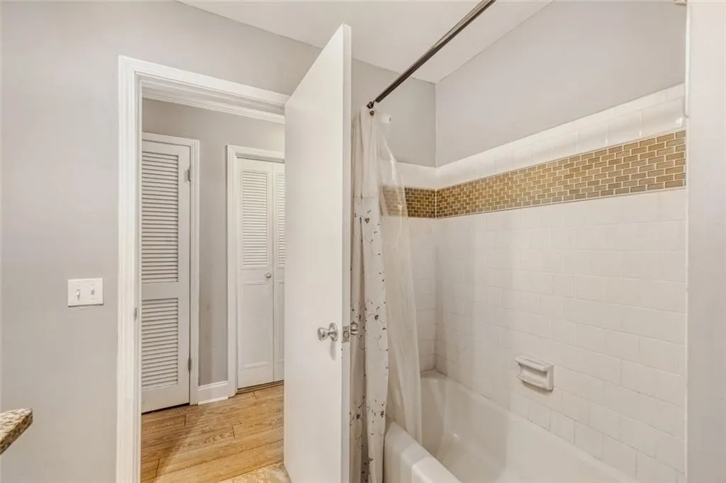 Bathroom featuring shower / bath combo with shower curtain and light wood-type flooring