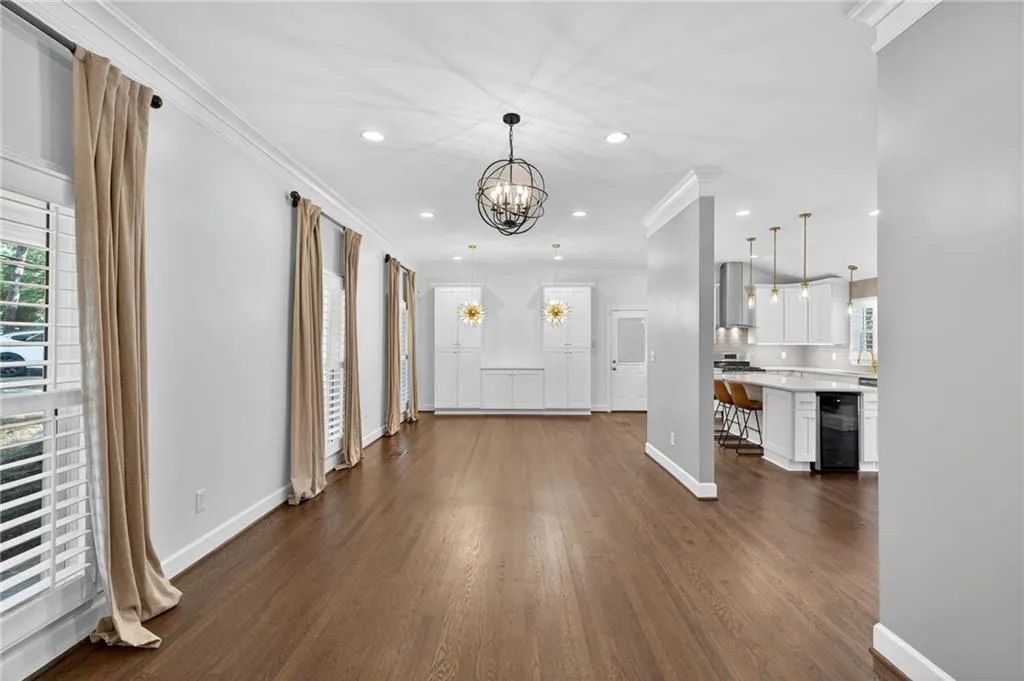 Foyer entrance featuring crown molding, healthy amount of natural light, dark wood finished floors, recessed lighting, and a chandelier