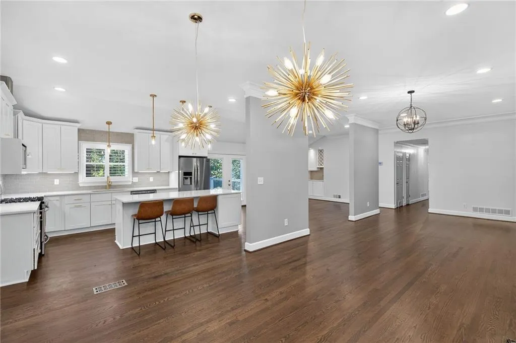 Kitchen with tasteful backsplash, white cabinets, a breakfast bar area, pendant lighting, and recessed lighting
