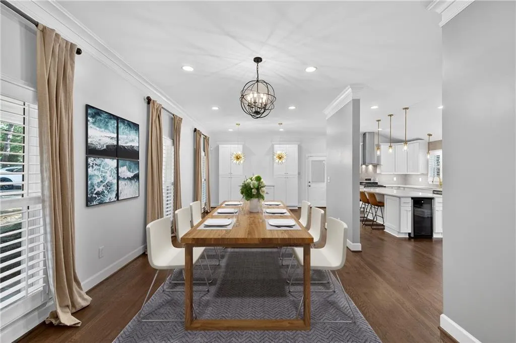 Dining space with crown molding, dark wood-type flooring, recessed lighting, a chandelier, and wine cooler