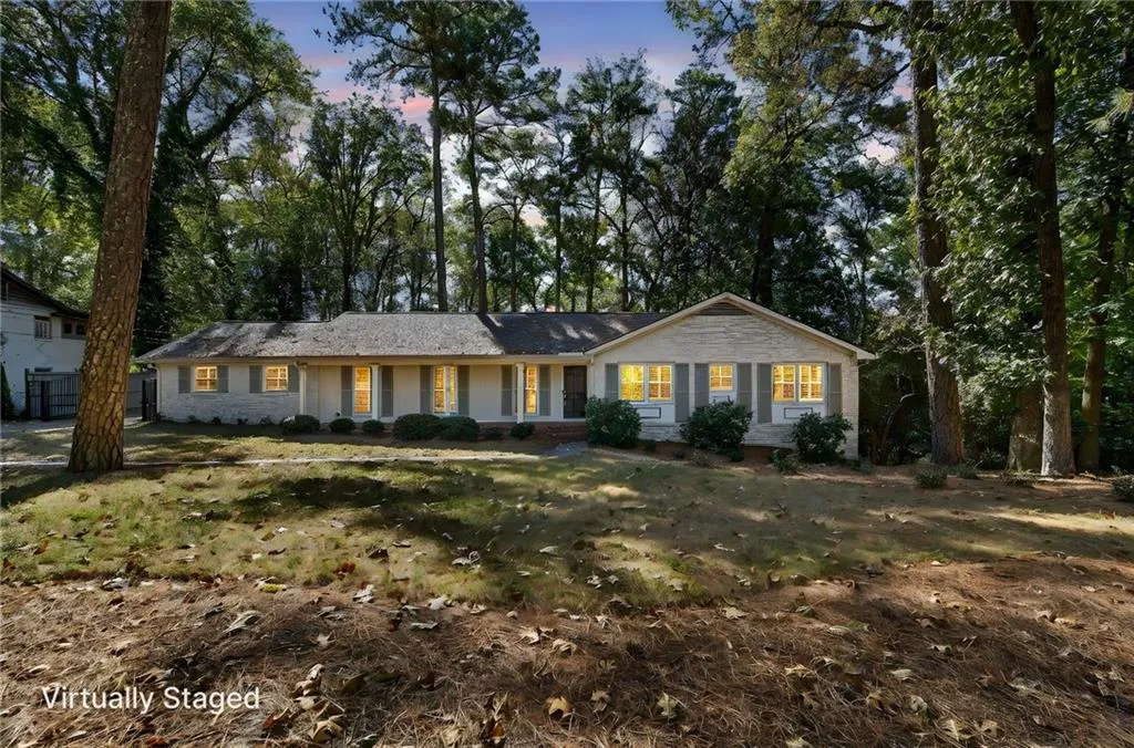 Ranch-style home with covered porch and view of wooded area
