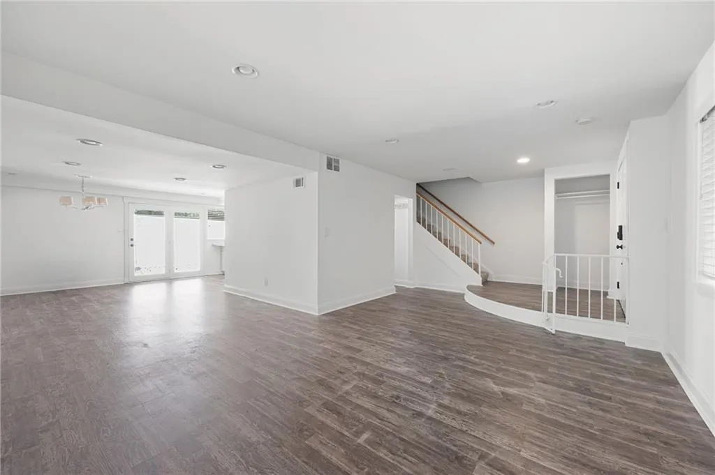 Empty room with a chandelier and dark hardwood / wood-style floors