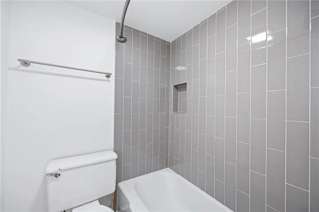 Bathroom featuring tiled shower / bath and toilet