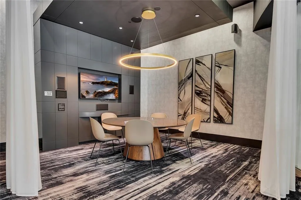 Integrated media wall with mounted television, recessed lighting, and a contemporary circular chandelier
