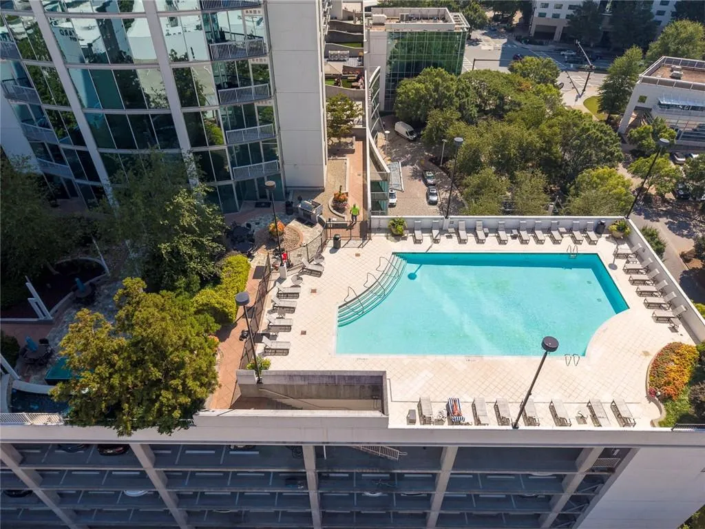 Rooftop amenities featuring a swimming pool, surrounding lounge area, and landscaped green spaces