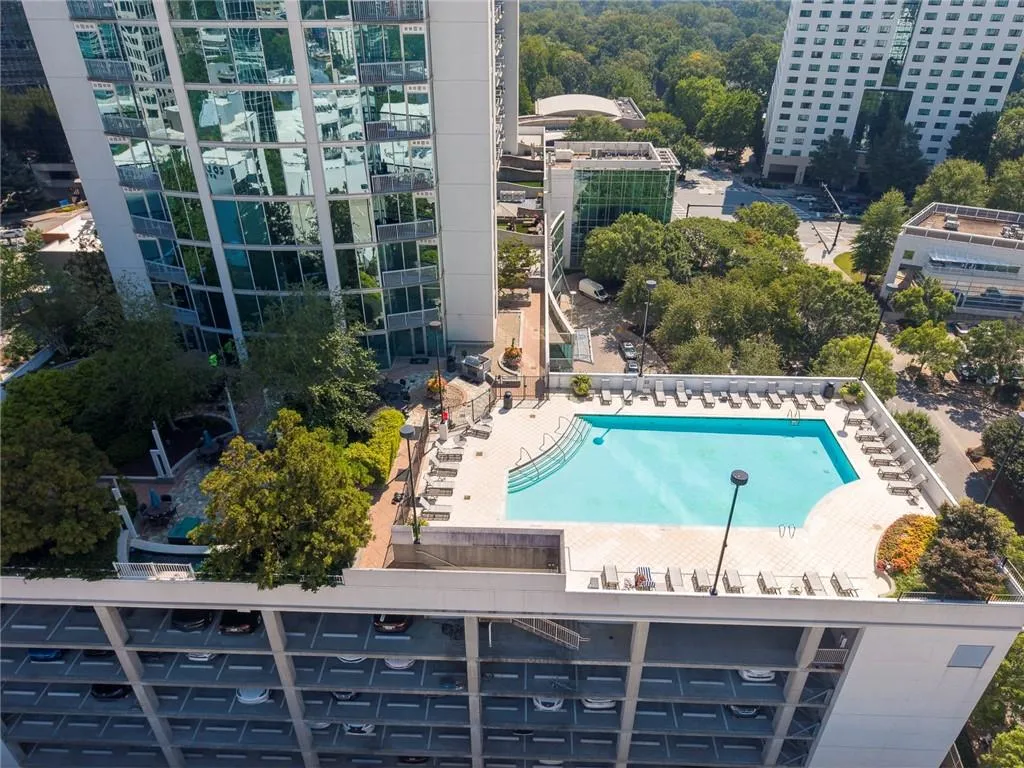 Rooftop swimming pool with integrated sun ledge, surrounded by a paved deck and multiple lounge chairs