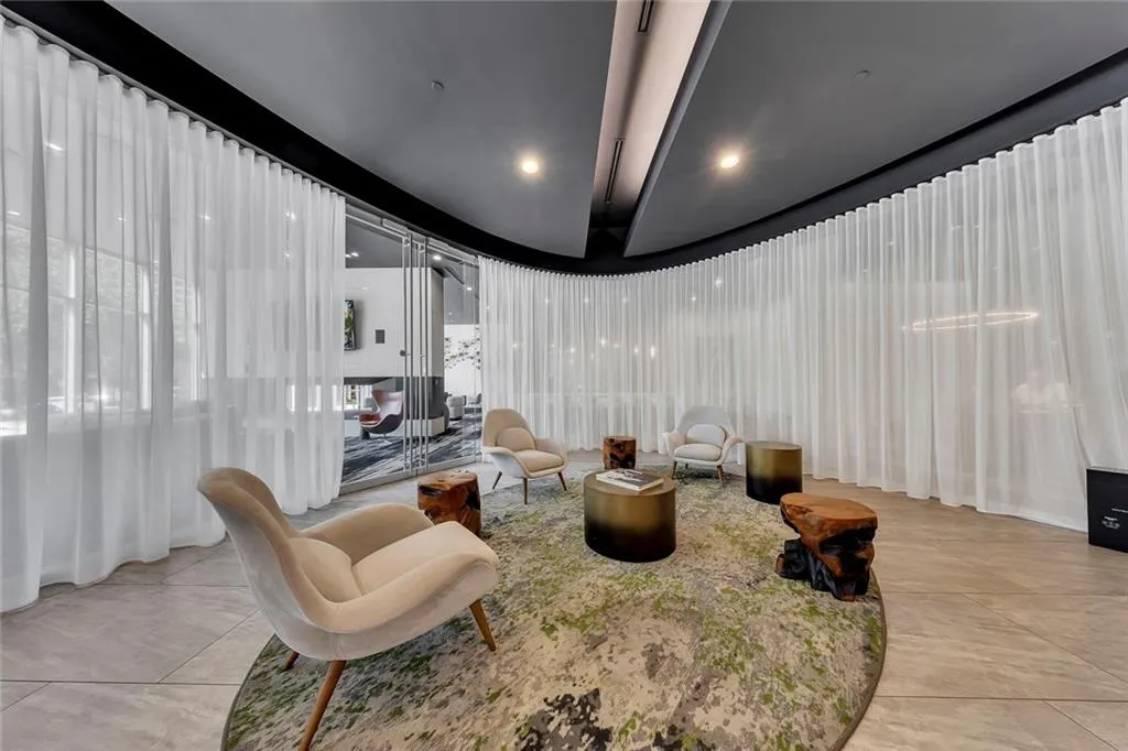 Curved wall of sheer window treatments, recessed lighting, and tile flooring