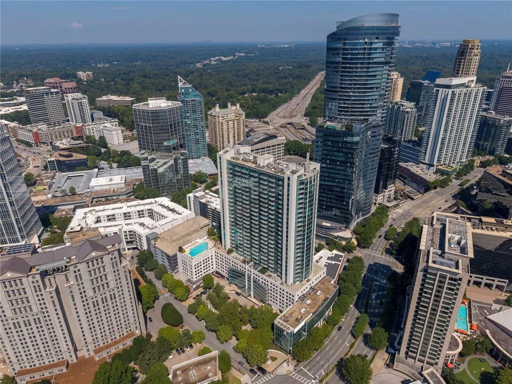 Aerial perspective showcasing a dense urban core with multiple high-rise structures, roadways, and green spaces