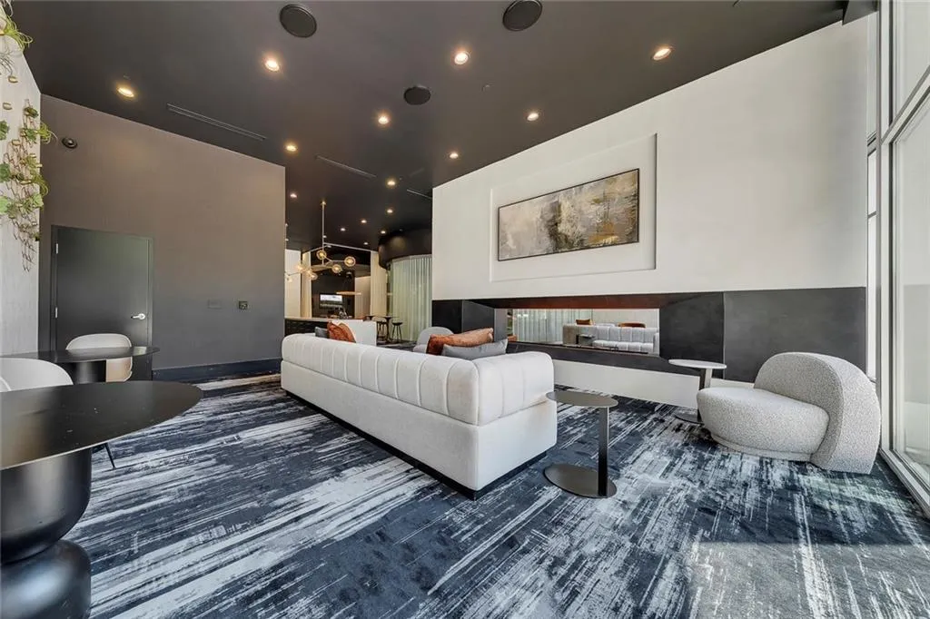 Recessed lighting, dark ceiling, built-in fireplace, large format window, dark broadloom carpet
