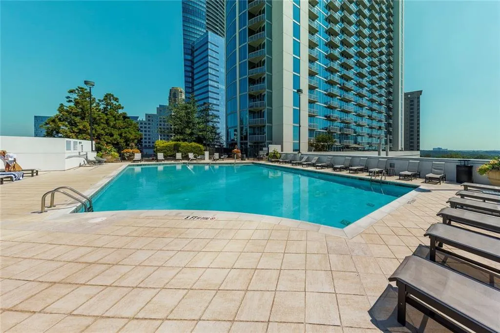 Rectangular swimming pool with tiled coping, surrounded by a large paver deck
