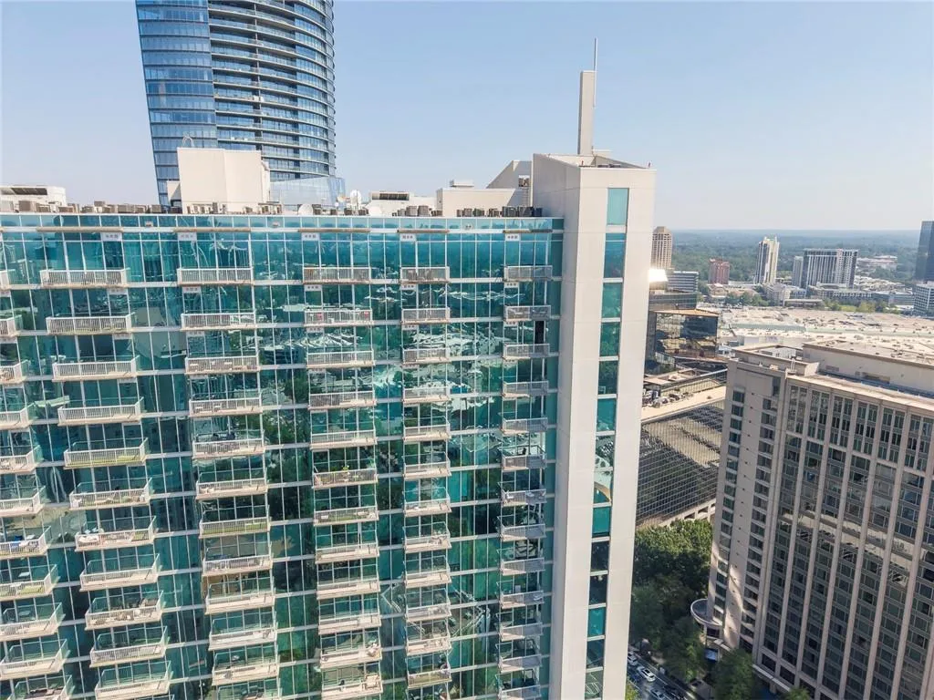High-rise structure with extensive glass facade, individual balconies, and a flat roofline