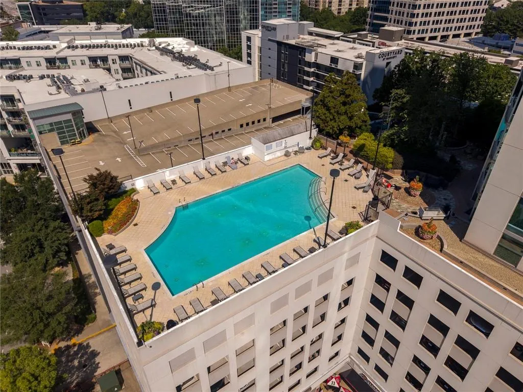 Rooftop amenity deck featuring a swimming pool, paved sundeck, and landscaped planters