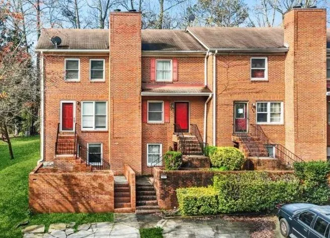 Brick exterior construction featuring multiple windows and a prominent chimney