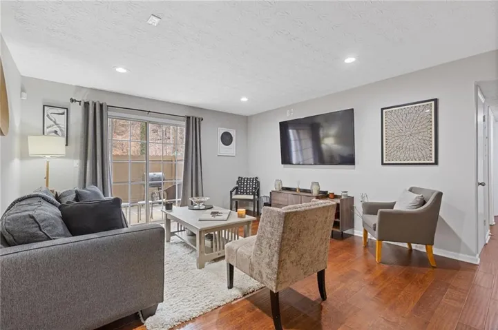 Wood-finish flooring, recessed lighting, and a sliding glass door providing outdoor access
