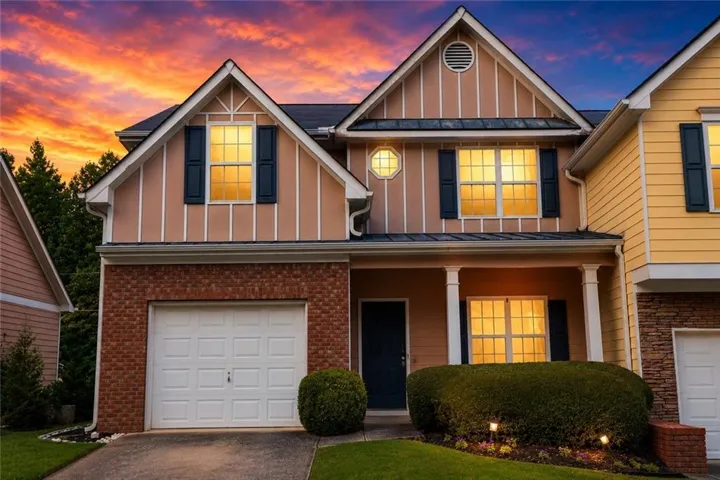 Brick and siding facade, attached garage, covered front porch, accent shutters, and landscaped entrance