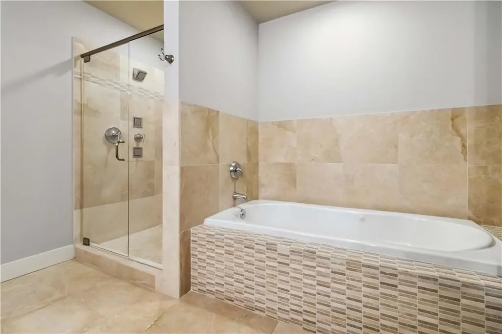 Full bathroom featuring a garden tub and a stall shower