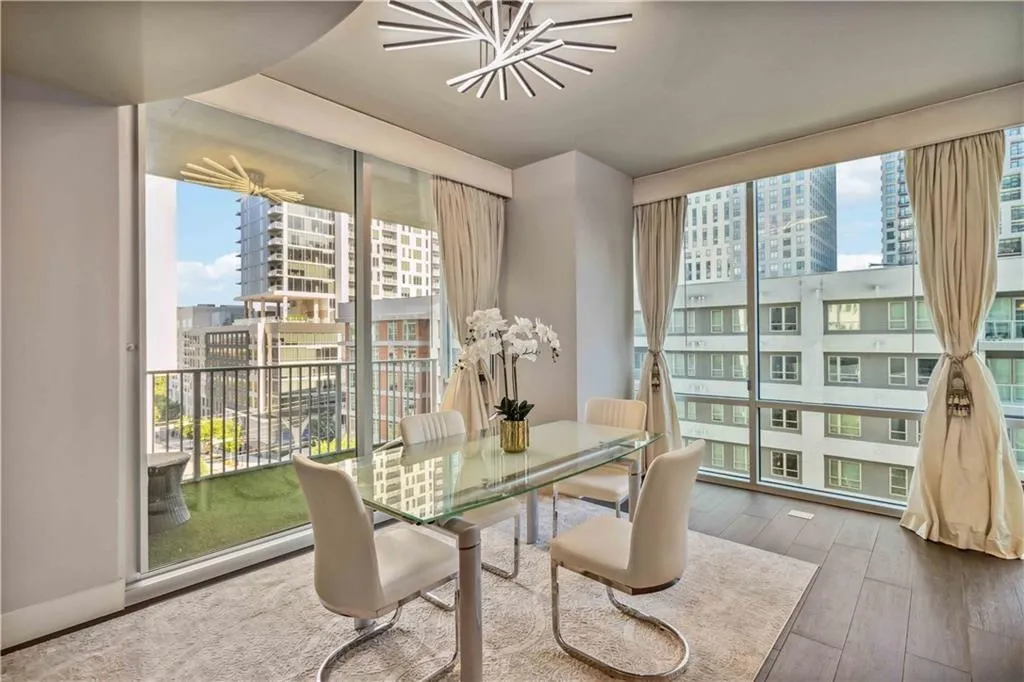 Dining area with a wall of windows, a city view, healthy amount of natural light, and wood finished floors
