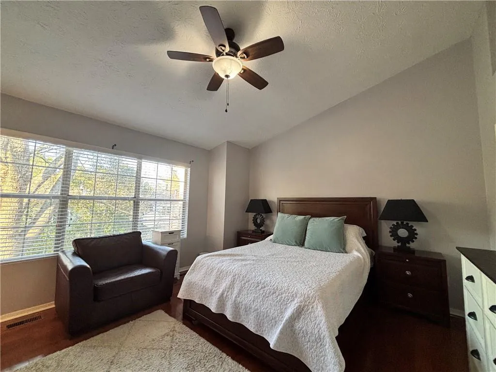 Spacious main bedroom with sitting area and large windows that look out into the back yard.
