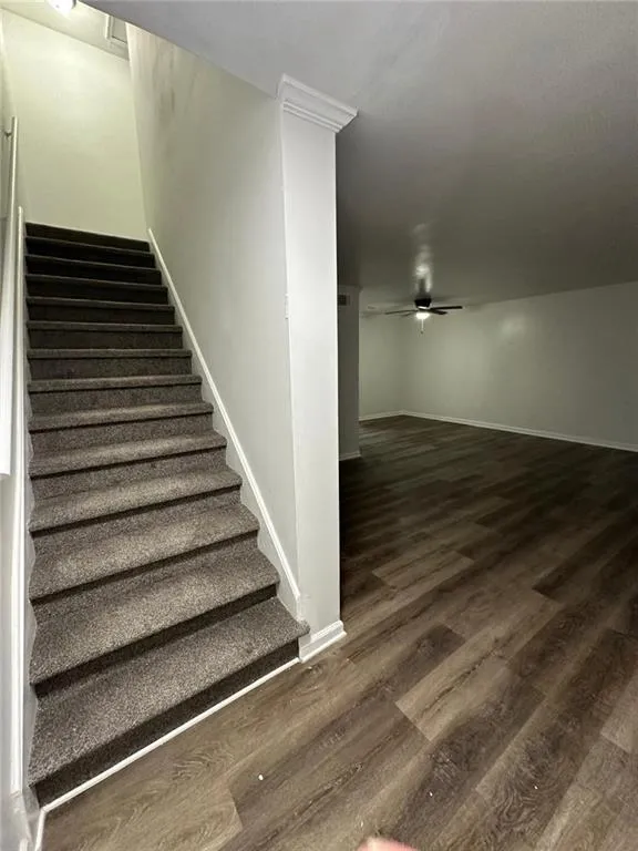 Stairs featuring ceiling fan and wood-type flooring