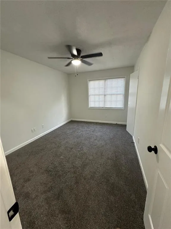 Carpeted spare room with ceiling fan