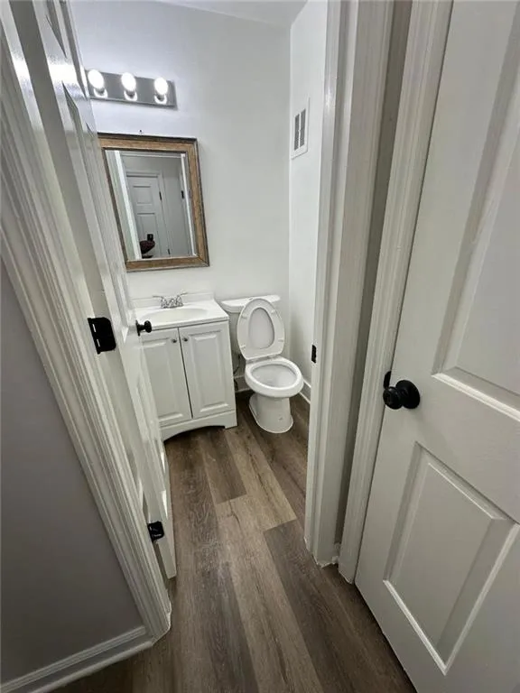 Bathroom with wood-type flooring, toilet, and vanity