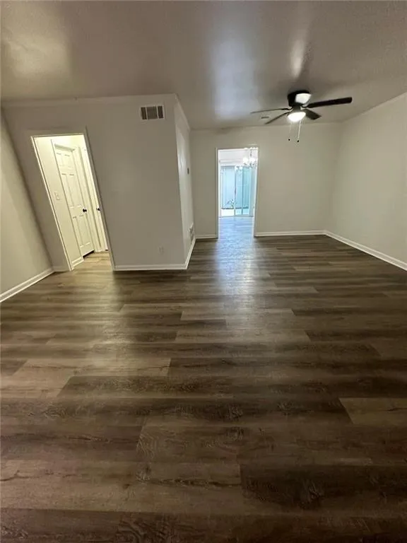 Spare room featuring ceiling fan, a textured ceiling, and dark wood-type flooring
