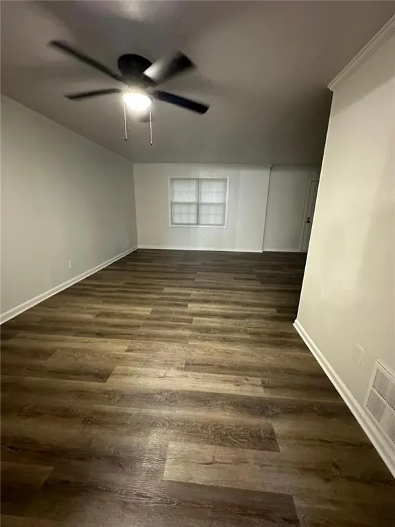 Spare room featuring ceiling fan and dark hardwood / wood-style flooring