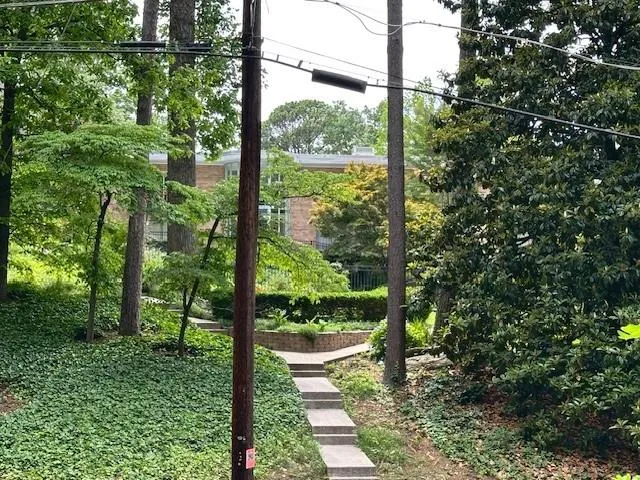 This is the street view. No need to use the stairs, the driveway on the right goes up to the top to the parking lot. If you do go up the stairs, you'll find the pool hidden from the street, You can also get to the pool from the top.