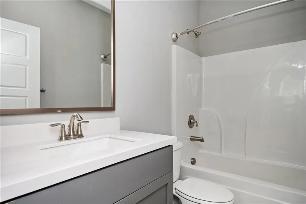 Bathroom with vanity, toilet, and shower / washtub combination