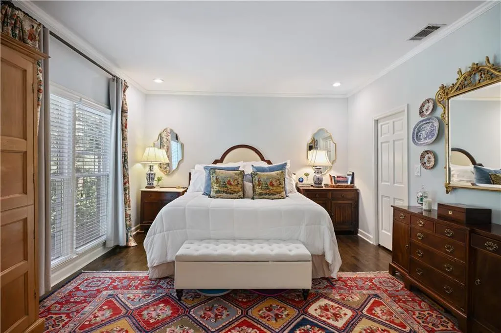 Hardwood flooring, recessed lighting, crown molding, white paneled door, and large window with blinds