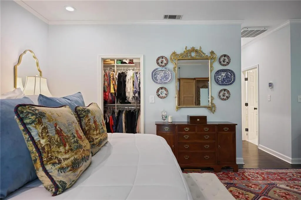 Recessed lighting, crown molding, built-in closet organization system, wood-finish flooring, and white baseboards