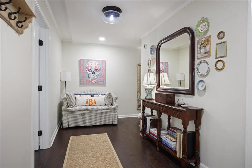Hardwood flooring, crown molding, recessed lighting, wall-mounted light fixture, and a built-in coat rack