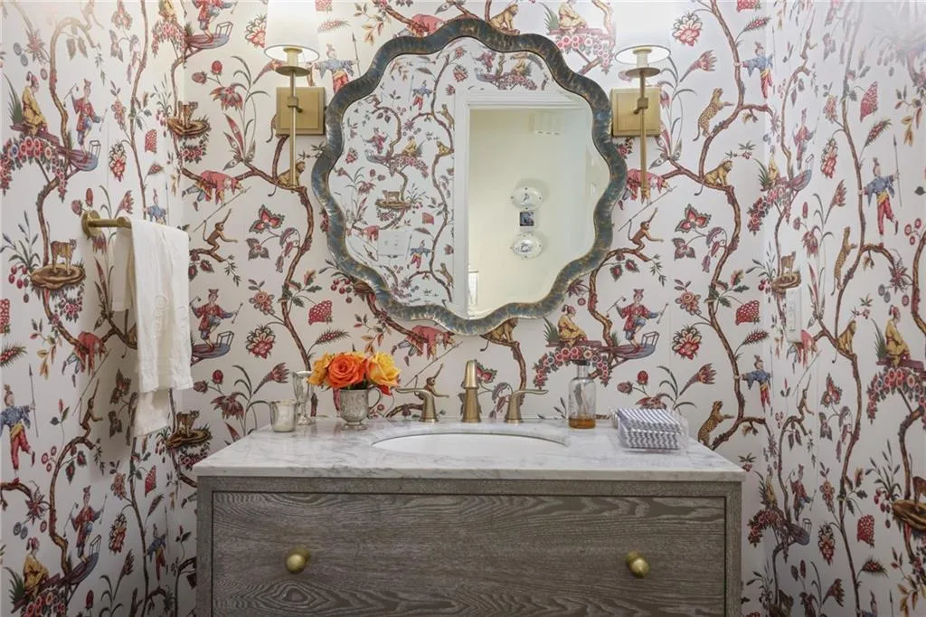 Custom vanity with a single basin, brass faucet, and marbled countertop