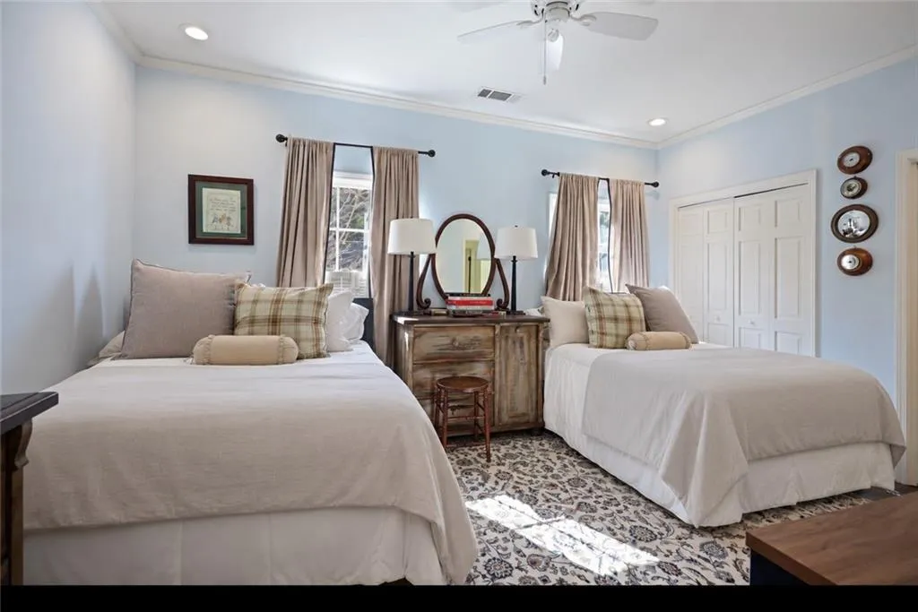 Recessed lighting, crown molding, double closet with bifold doors, window with drapes, and ceiling fan