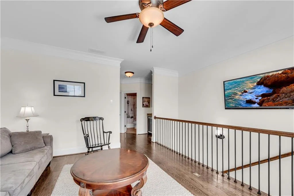 Living room featuring crown molding, dark hardwood / wood-style floors, and ceiling fan
