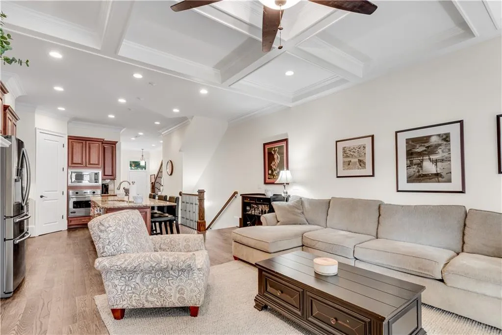 Living room with crown molding, hardwood / wood-style floors, beamed ceiling, and coffered ceiling