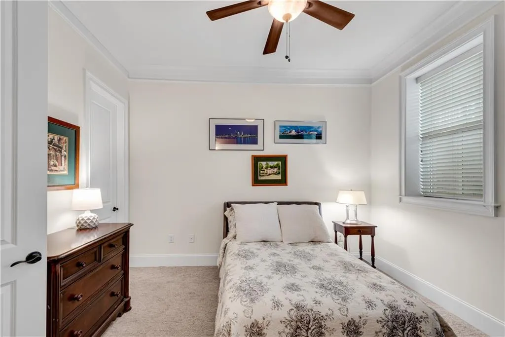 Bedroom featuring crown molding, light colored carpet, and ceiling fan