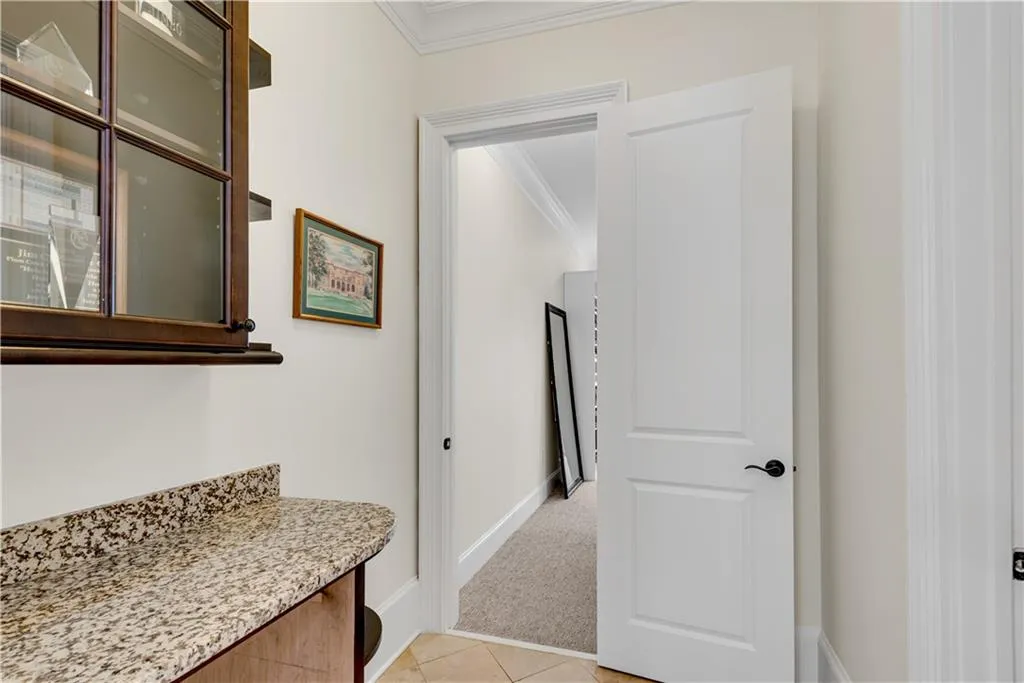 Corridor featuring light carpet and ornamental molding
