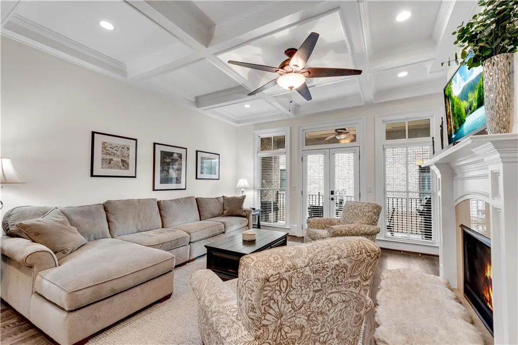 Living room featuring light hardwood / wood-style floors, coffered ceiling, and beamed ceiling