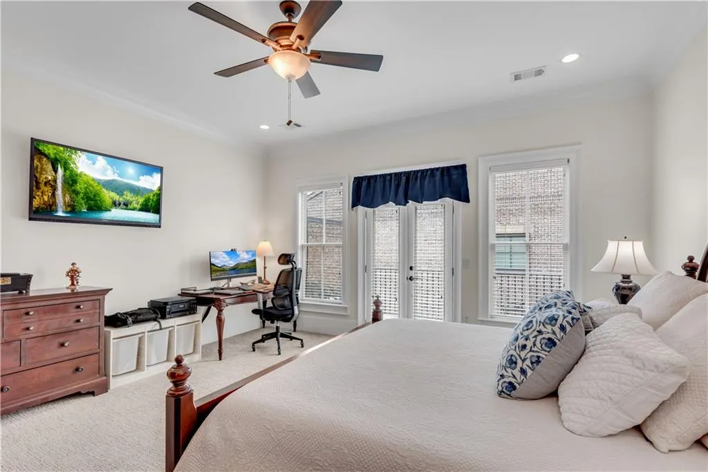 Bedroom with french doors, access to exterior, ceiling fan, crown molding, and carpet