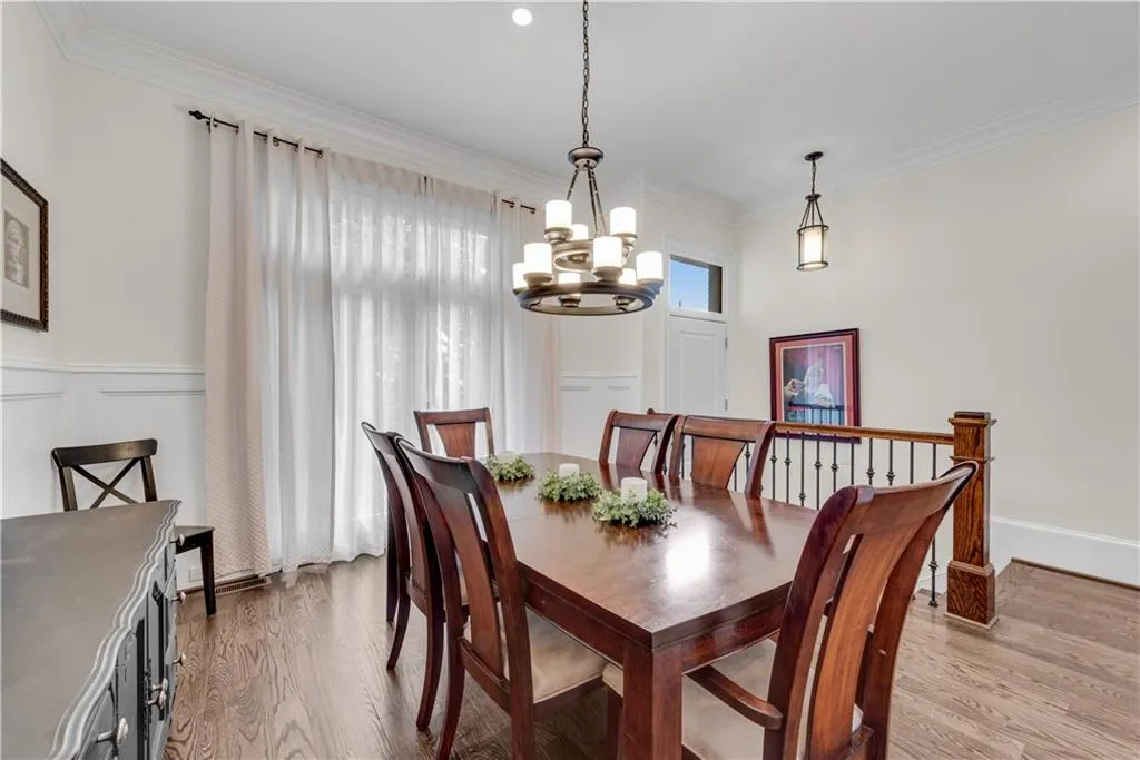 Dining area with an inviting chandelier, ornamental molding, and light wood-type flooring