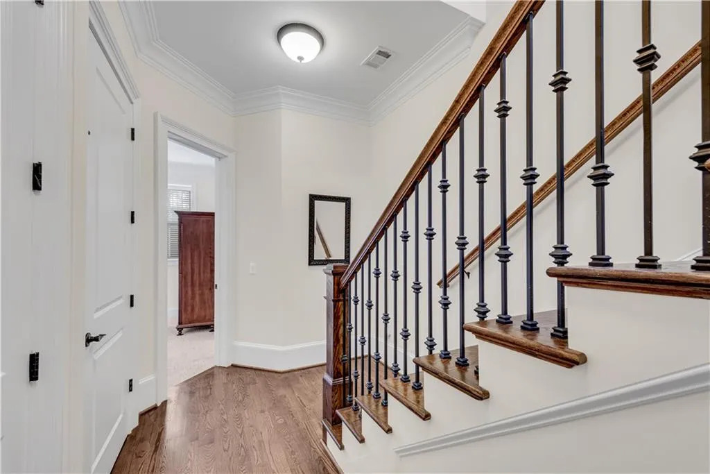 Stairs with hardwood / wood-style flooring and ornamental molding