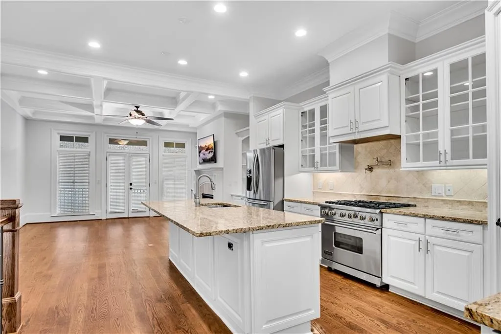 Kitchen featuring white cabinetry, stainless steel appliances, wood-type flooring, and sink
