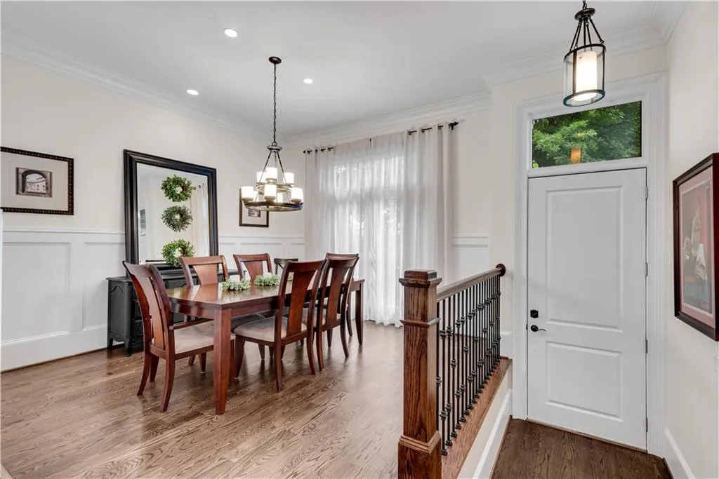 Dining area with a notable chandelier, crown molding, and hardwood / wood-style flooring