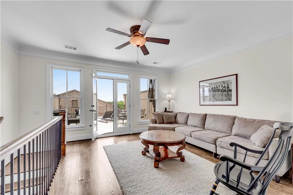 Living room featuring crown molding, hardwood / wood-style flooring, and ceiling fan